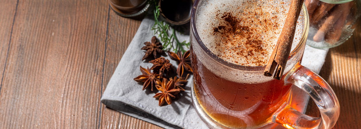 Zelfgemaakte winterdrankjes met kaneel op een houten tafel