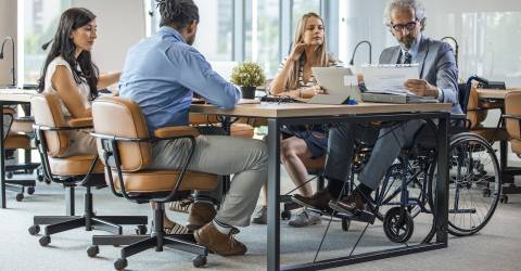 Zakelijke bespreking met mannen en vrouwen waarvan 1 man in rolstoel