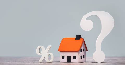 Hypotheek; wit procentteken, afbeelding van een huis en een groot wit vraagteken op een grijze achtergrond